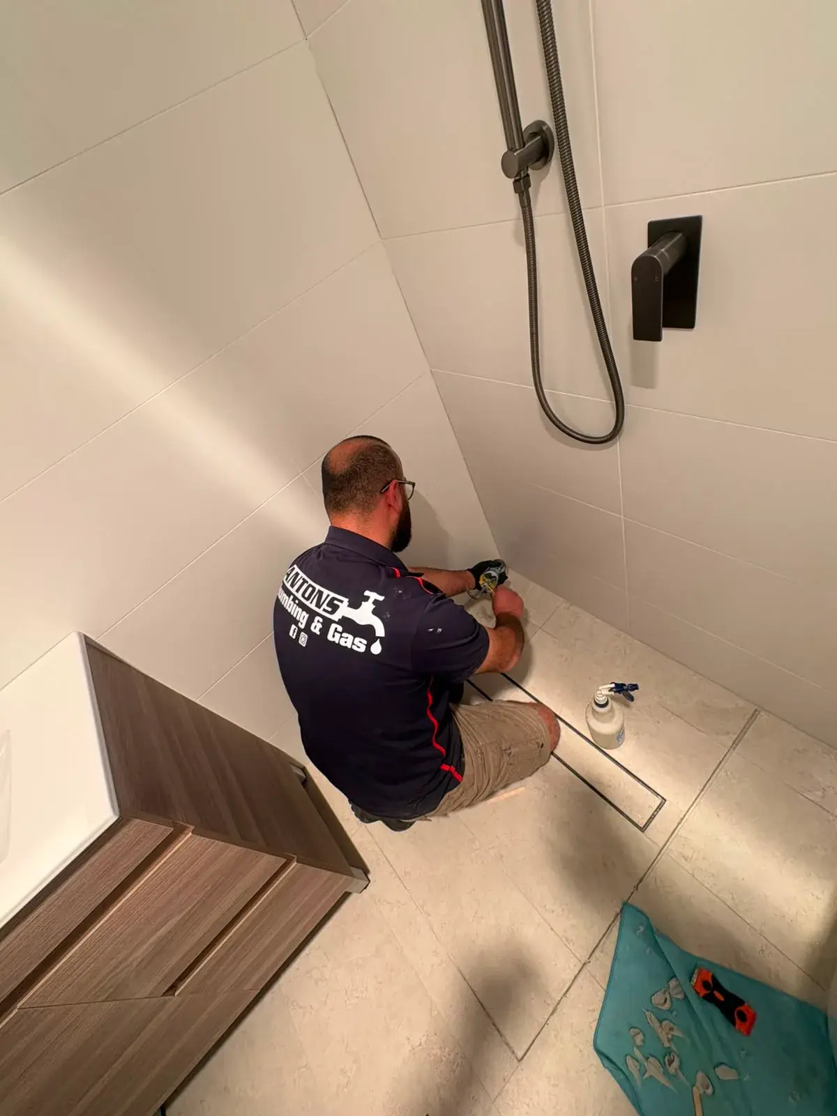 Ryde plumber from Antons completing a bathroom floor-drain repair