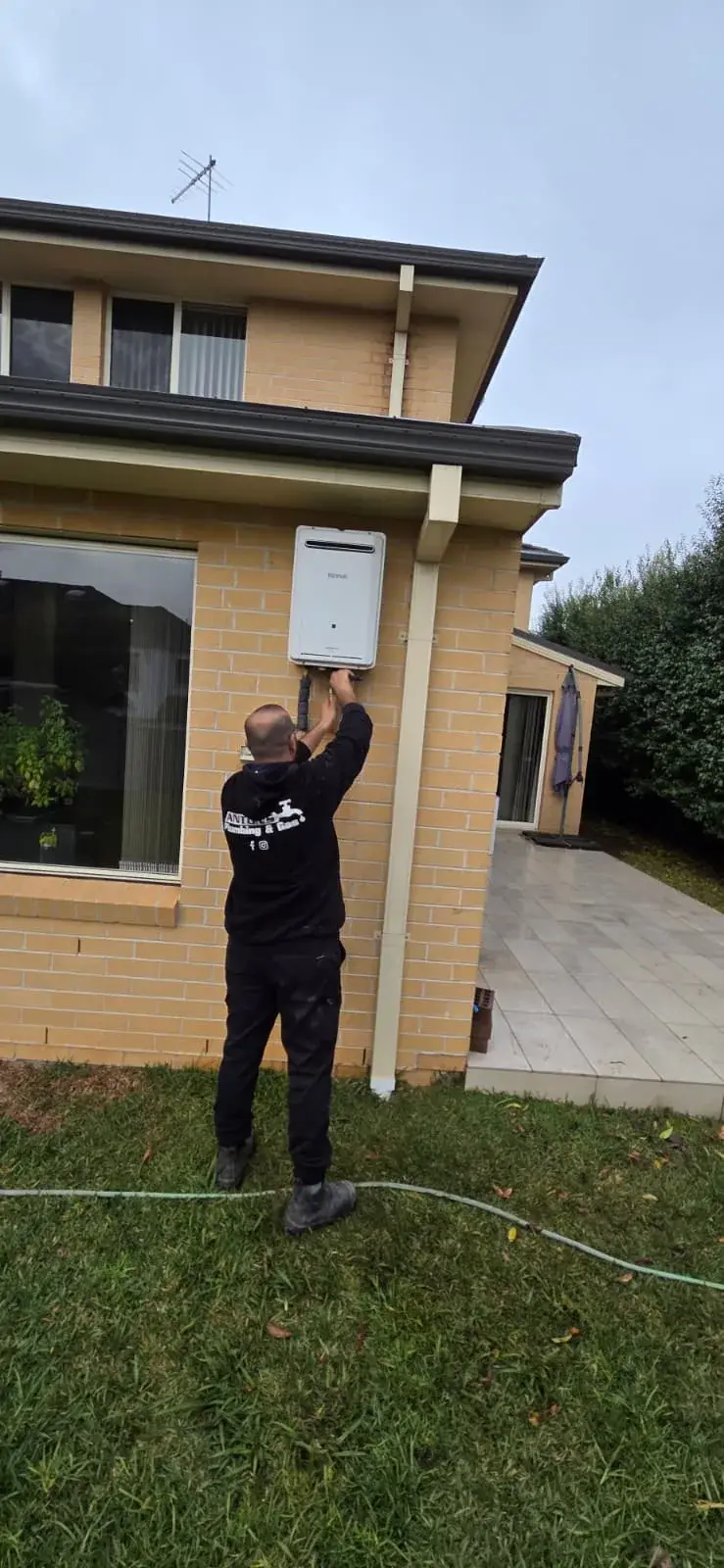 Ryde plumber from Antons servicing an external hot-water appliance