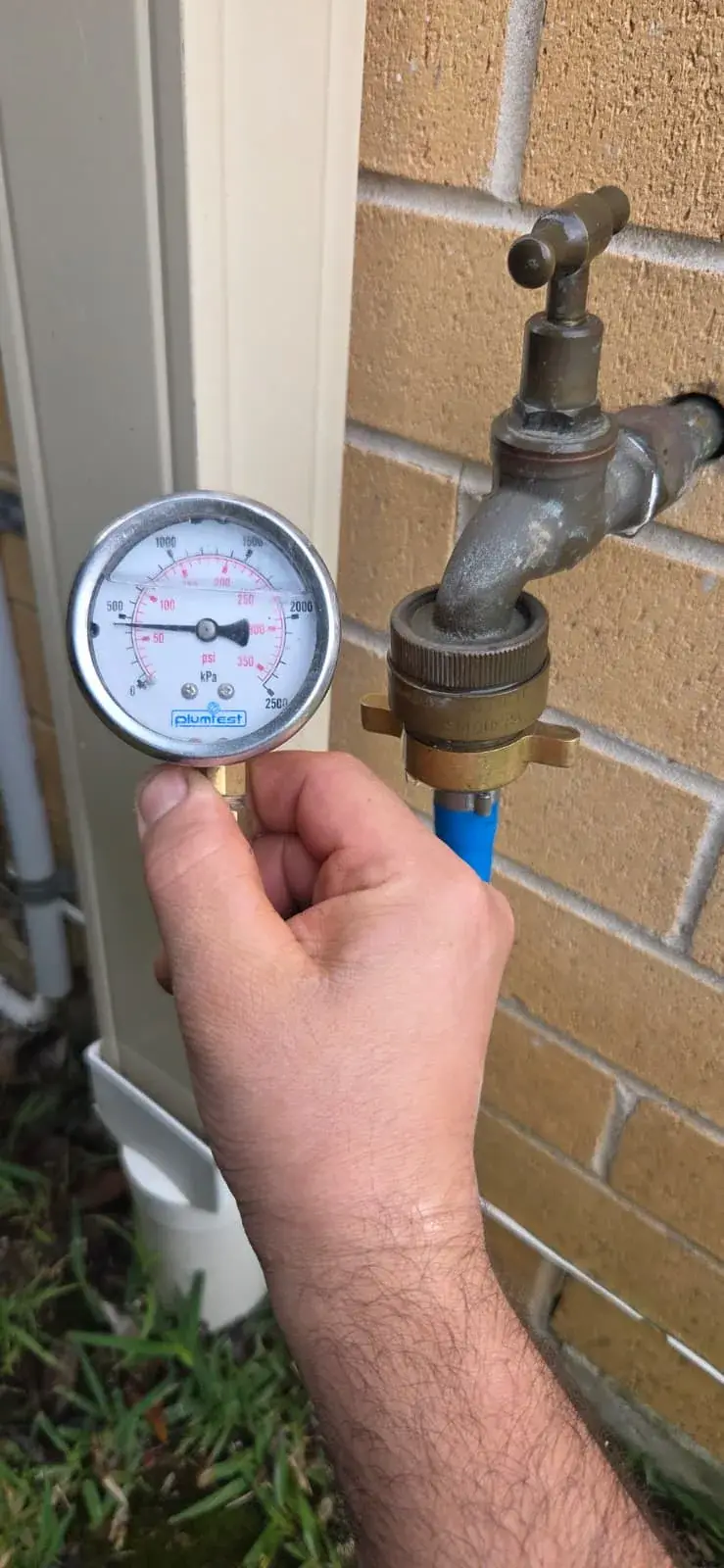 Ryde plumber from Antons checking water pressure at an outdoor tap
